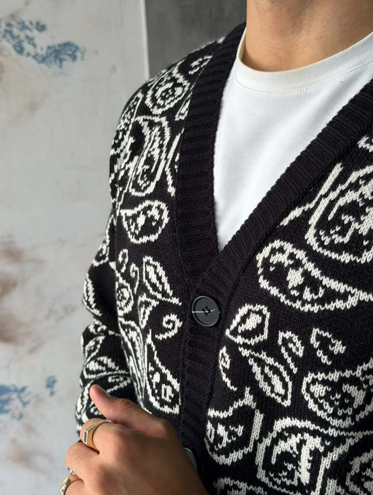 Gilet Triko Paisley – Noir – worn – close-up detail of black paisley cardigan fabric and button closure