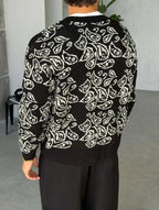 Gilet Triko Paisley – Noir – worn – back view of model wearing black paisley jacquard knit cardigan sweater