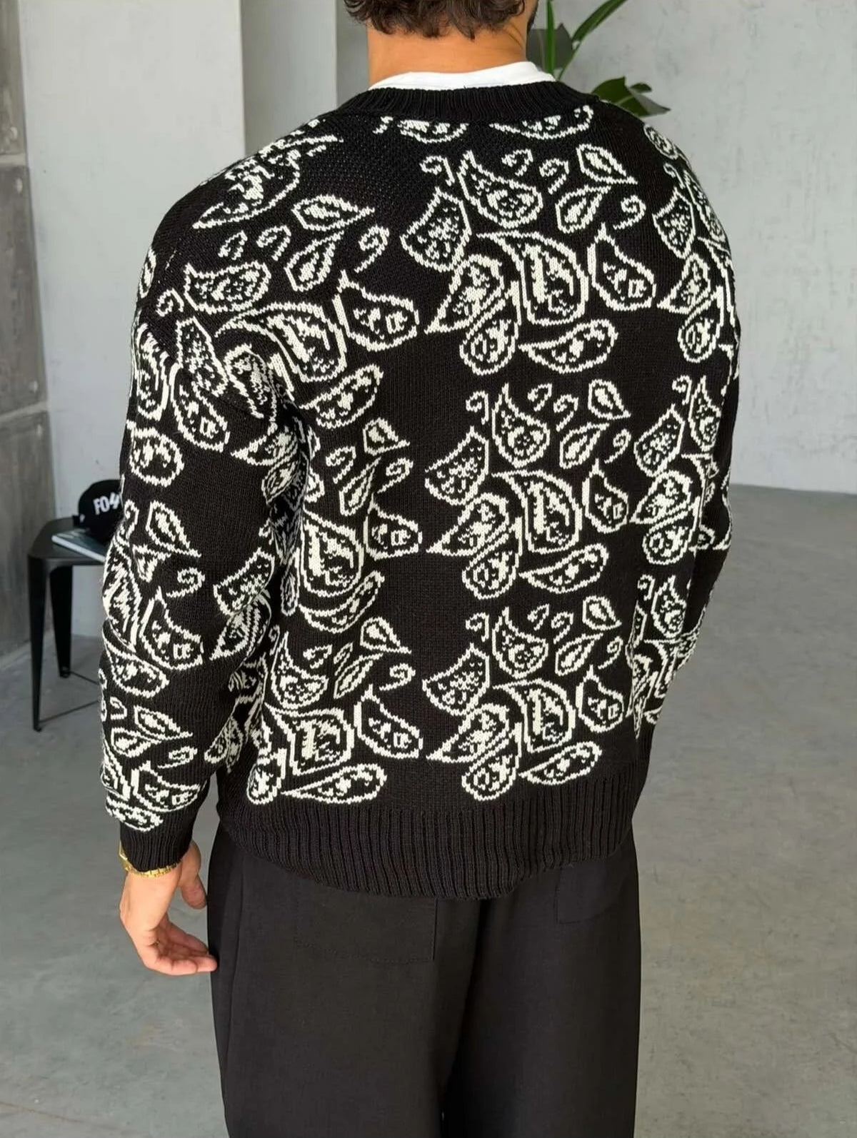 Gilet Triko Paisley – Noir – worn – back view of model wearing black paisley jacquard knit cardigan sweater