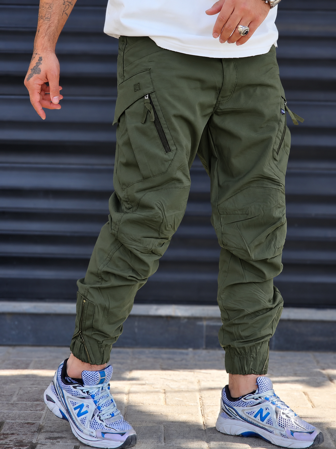 Jogger Utility – Green – worn – olive green cargo jogger pants with zippered thigh pockets and ankle zips