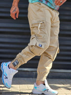 Jogger Pant Vibe – Beige – worn – beige cargo jogger pants shown from side with zip pocket detail